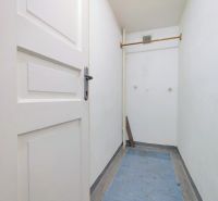 Narrow corridor with wooden doors and a coat rack in the offices.