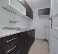 A small kitchen with dark cabinets and tiles, without visible appliances.