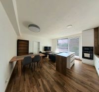 A spacious kitchen with built-in appliances and a wooden decor floor in a 3-room apartment.