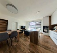 A kitchen in a 3-room apartment with a wooden decor floor and a dining table.