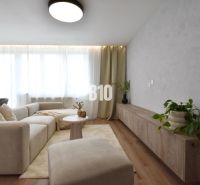 Living room in a 4-room apartment with a couch, table, and floor with a wooden decor.