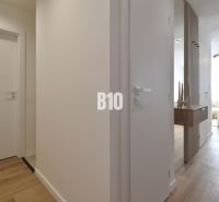 Interior of a 4-room apartment with a wooden decor floor and minimalist furniture.