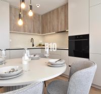 Dining room in a 4-room apartment with a round table and a floor with a wooden decor.
