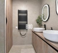 A bathroom in a 4-room apartment with oval mirrors and furniture with a wooden decor.