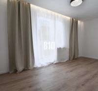 A bright room with a wood-patterned floor and a large window in a 4-room apartment.