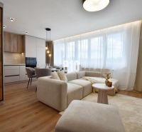 Living room with a light sofa, dining area, and kitchen in a 4-room apartment.