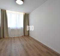 A room with curtains and a wooden decor floor in a 4-room apartment.