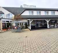 The exterior of the hotel in Veľký Lapáš with a paved courtyard and bicycle decoration.