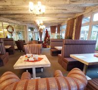 Interiors of hotels and guesthouses with comfortable sofas, wooden tables, and Christmas decorations.