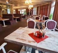 A restaurant with wooden tables, comfortable seating, and decorative lighting in hotels and guesthouses.