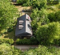 Aerial view of a cabin in Banská Bystrica surrounded by greenery and trees.