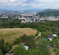 A view of cottages around Banská Bystrica with hills and the city on the horizon.
