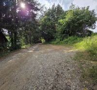 The driveway to the cottage in Banská Bystrica, surrounded by greenery and trees.