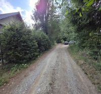A forest path near a cottage in Banská Bystrica, surrounded by trees and greenery.