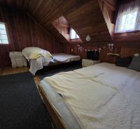 The interior of a wooden cabin with skylights and comfortable beds.