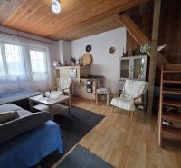 Interior of a cabin with a fireplace, sofa, and wooden decor flooring, cozy atmosphere.