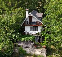 A cottage in the vicinity of Banská Bystrica surrounded by dense trees and greenery.