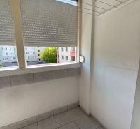 A balcony with ceramic tiles, a drying rack, and a view of the surrounding buildings in a 3-room apartment.