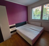 Bedroom in a 3-room apartment with two beds, a wardrobe, and a floor with a wooden decor.