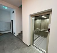Entrance hall with elevator and staircase, tiles, and mailboxes.