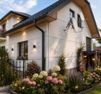 A family house in Kosorín with a landscaped garden and satellite dishes on the wall.
