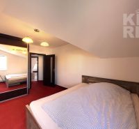 A bedroom in a two-room apartment with a red carpet and a built-in wardrobe.