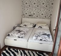 A bedroom in a 3-room apartment with a decorative wall and a floor with a wood decor.