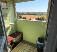 The balcony of a 3-room apartment in Levice with a view of fields and greenery.