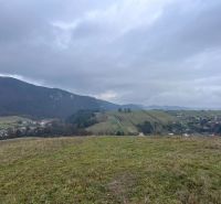 A view of agricultural and forest lands in Stránske with hills and a village.