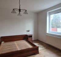 Bedroom in a family house with a double bed, nightstands, and a wooden decor floor.