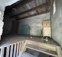 Interior of commercial premises with a wooden ceiling, stairs, and storage items.