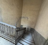 An older staircase with decorative railing in commercial premises.