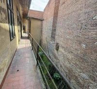 A narrow balcony with a brick wall in commercial premises on the Main Square in Šahy.