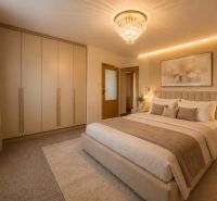 A bedroom in a 3-room apartment with a large bed, built-in wardrobes, and a chandelier.