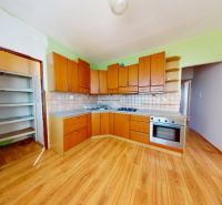 A kitchen in a 3-room apartment with a wooden decor floor and built-in appliances.