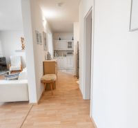 Hallway with entrance to the living room in a 3-room apartment, floor with wooden decor.