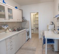 A kitchen in a 3-room apartment with a kitchen unit, dining table, and folding shelves.