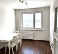 Bright dining room in a 3-room apartment with a white table and wood-patterned flooring.