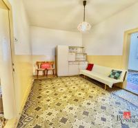 A room in a family house with a sofa, cabinet, and a retro carpet in decorations.