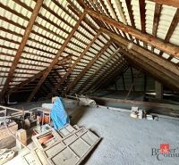 Attic in a family house with wooden beams, Kosorín, mess and various tools on the ground.