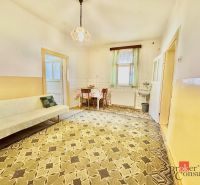 Room with carpeted floor, sofa, and table in a family house.
