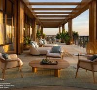 A terrace in Miami with comfortable seating, plants, and a view of the sunset.