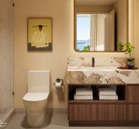 A bathroom in a studio apartment with a marble sink and a glass shower enclosure.