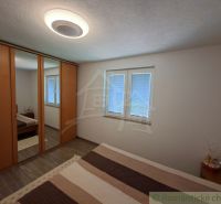 A bedroom in a family house with a large wardrobe and a floor with a wooden decor.