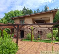 A family house in Veľké Uherce surrounded by a pergola and garden paving.