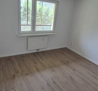 A room in a 3-room apartment with a window and a floor with a wooden decor.