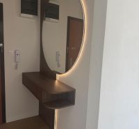 Mirror with LED light and furniture in a 3-room apartment, floor with wood decor.