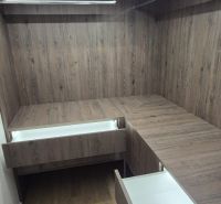 A hallway with a wardrobe and drawers in a 3-room apartment, floor with wood decor.