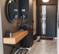 In the family house, there is a counter with decoration, a mirror, and an entrance door.