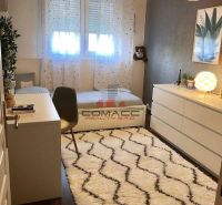 Children's room in a family house with a white carpet and a wooden decor floor.